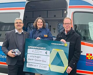 Primion hands over donation cheque to ASB in front of the ‘’Wish Car‘’.