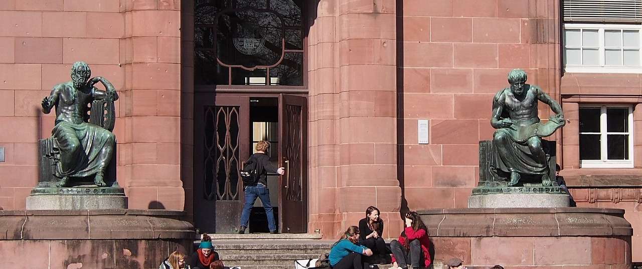 Entrance of AlbertLudwigs University in Freiburg, Germany, with students sitting on the stairs